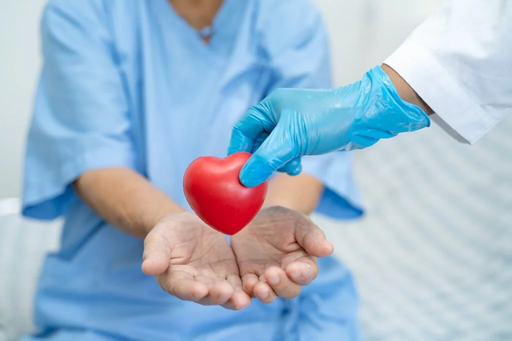 Doctor give red heart to Asian senior woman patient, healthy strong medical concept