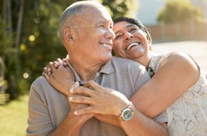 Love, hug and happy old couple in garden, laugh and marriage with retirement together in nature wit